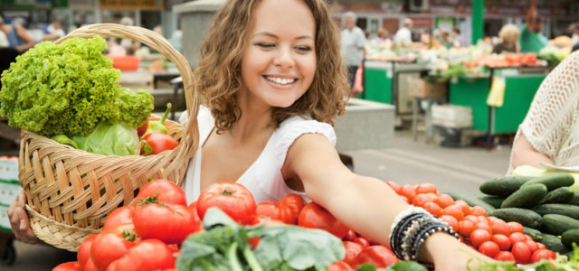 Young woman buying fresh vegetables to support her microbiome and mood