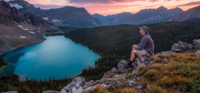 A man sitting on rocks and taking in the beauty around him because IV ketamine allows him to enjoy a moment.