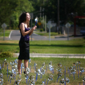 A relaxed lady blows a dandelion in a field after ketamine IV, IM, or IN for depression.