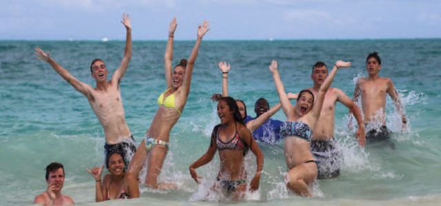 Teen playing in surf after treatment because teen exhibit signs of bipolar disorder.