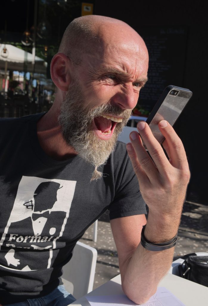 This man shouts into his phone because his amygdala tells him to fight.